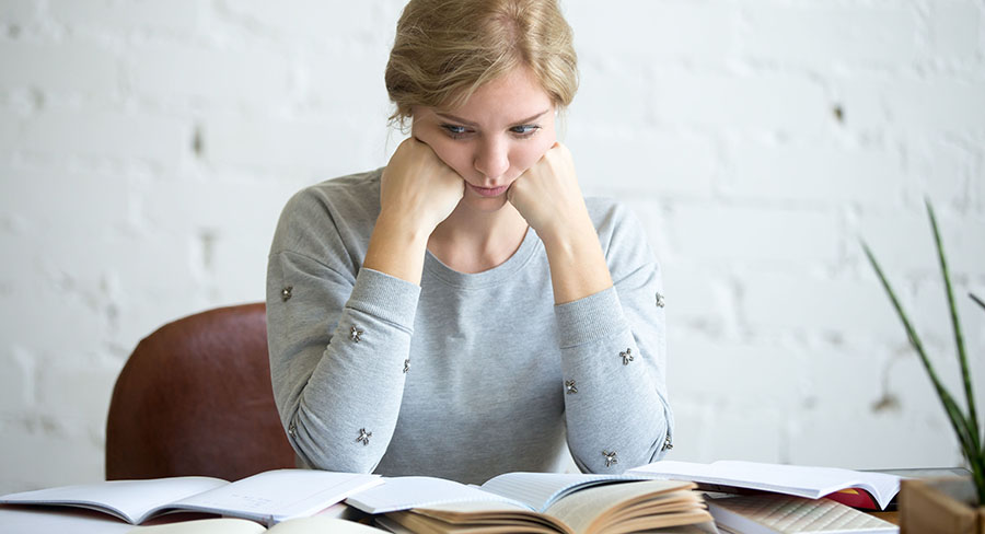 Portrait of a tired student woman at the desk