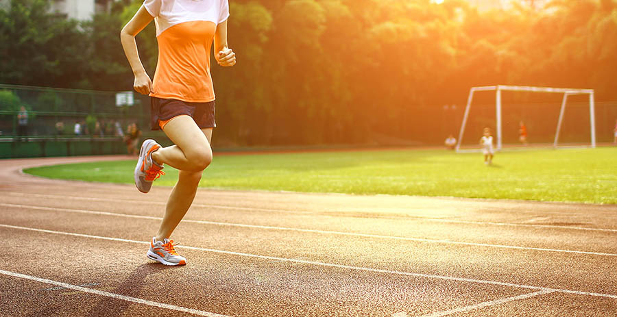 Athletic woman running on track